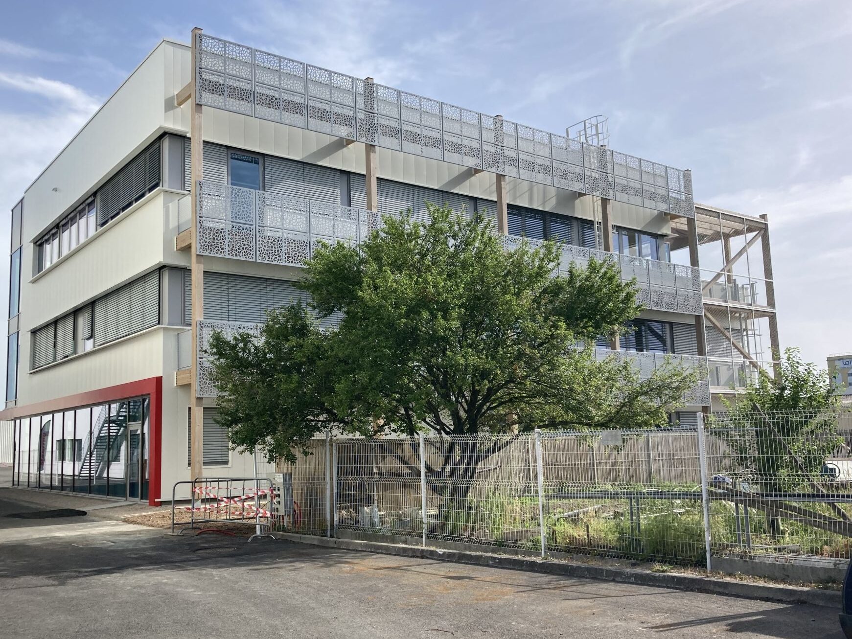 Bâtiment moderne de plusieurs étages avec façade claire et espace paysager