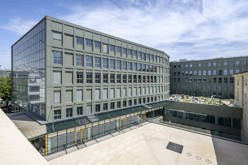 Vue extérieure du nouvel hôpital Lariboisière mettant en valeur sa façade contemporaine, son entrée vitrée, ses toitures-terrasses et ses espaces extérieurs aménagés.
